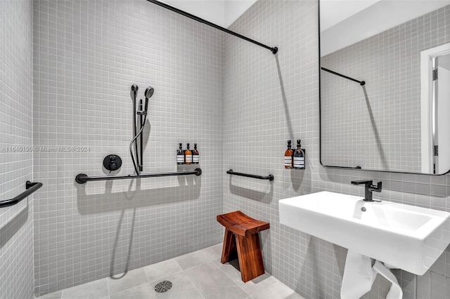 bathroom with tiled shower, tile walls, tile patterned floors, and sink