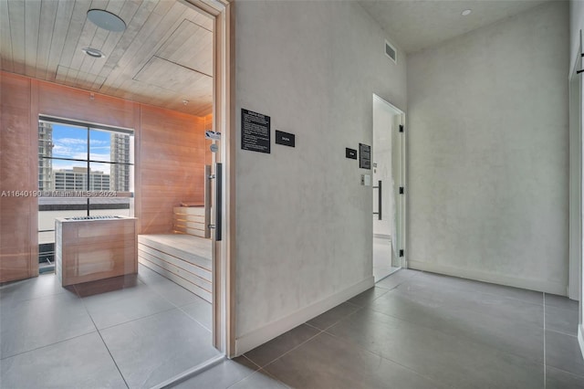 hall featuring wooden walls and tile patterned flooring