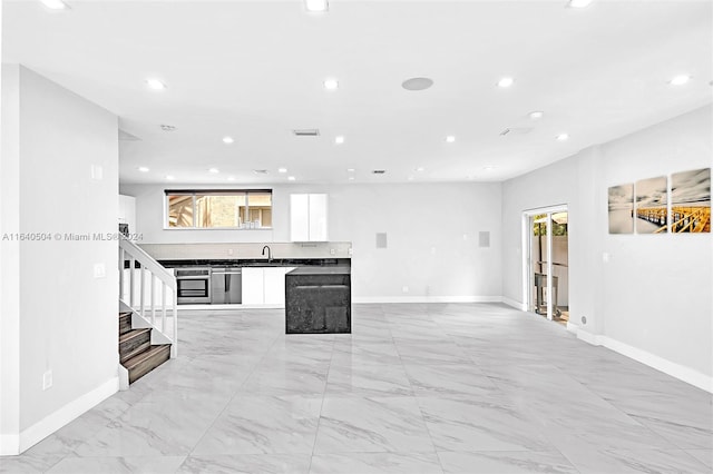 kitchen featuring appliances with stainless steel finishes, white cabinetry, and sink