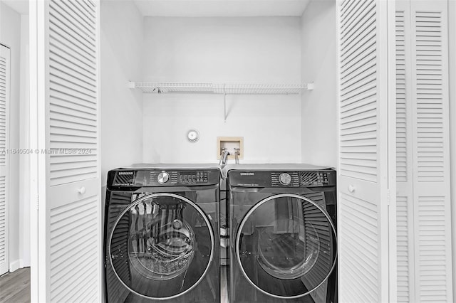 laundry room featuring hardwood / wood-style flooring and washing machine and dryer