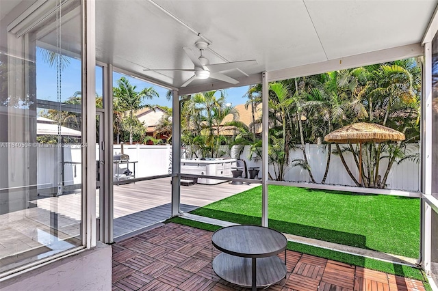 unfurnished sunroom featuring ceiling fan