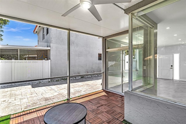 unfurnished sunroom with ceiling fan