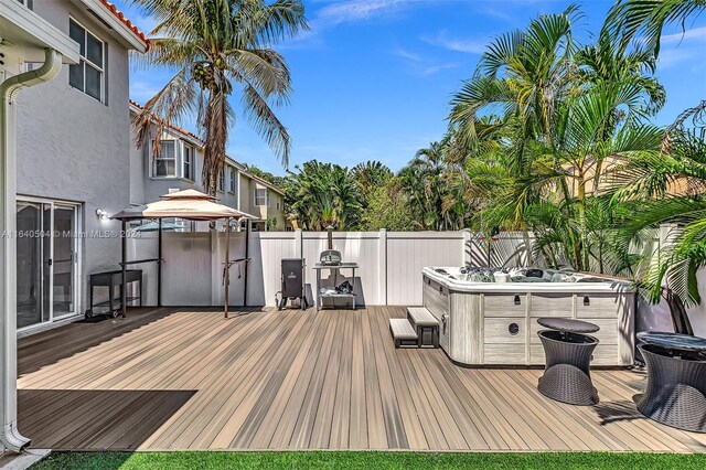 wooden deck with a gazebo and a hot tub