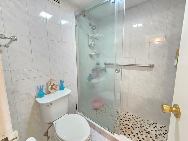 bathroom featuring toilet, tile walls, and an enclosed shower