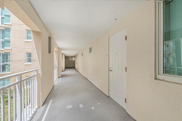 corridor with a textured ceiling and a healthy amount of sunlight