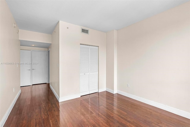 unfurnished bedroom with a closet and hardwood / wood-style flooring