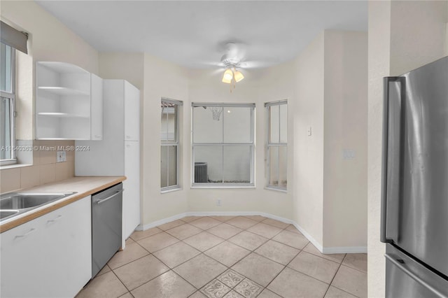 kitchen featuring ceiling fan, white cabinets, light tile patterned floors, and stainless steel appliances