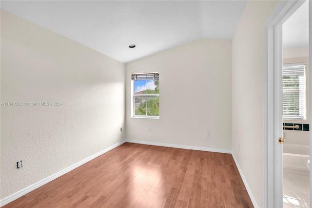 empty room featuring wood-type flooring and lofted ceiling