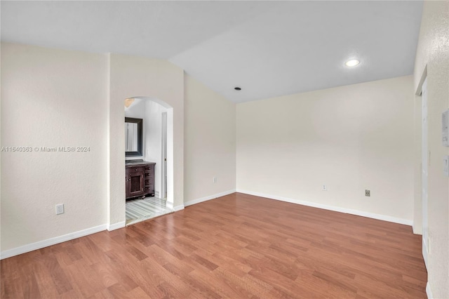 unfurnished living room featuring vaulted ceiling and hardwood / wood-style flooring