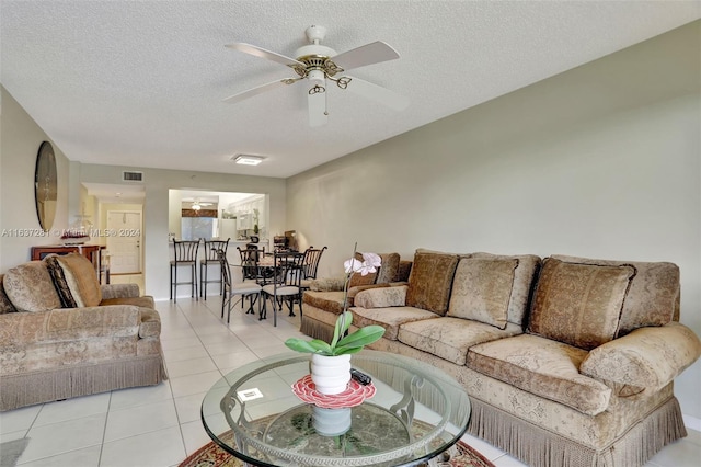 living area with visible vents, ceiling fan, a textured ceiling, and light tile patterned floors