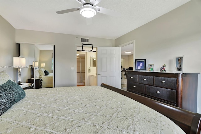 bedroom featuring a textured ceiling, visible vents, and a ceiling fan