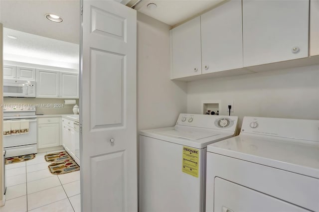 laundry room featuring recessed lighting, light tile patterned flooring, cabinet space, and washer and clothes dryer