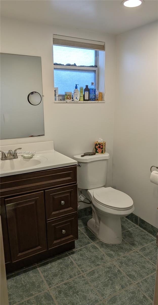 bathroom featuring toilet, tile patterned flooring, and vanity