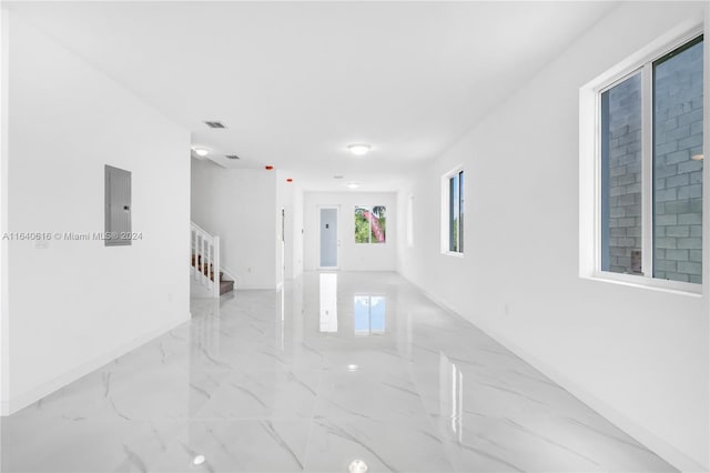 corridor featuring electric panel and light tile patterned floors