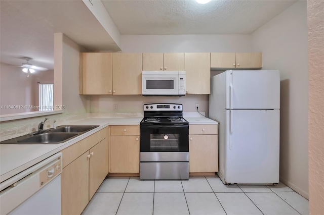 kitchen with a textured ceiling, sink, white appliances, and light brown cabinets