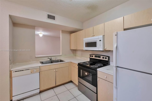 kitchen featuring white appliances, a textured ceiling, sink, light brown cabinets, and light tile patterned floors