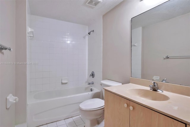 full bathroom with vanity, tile patterned flooring, tiled shower / bath combo, toilet, and a textured ceiling