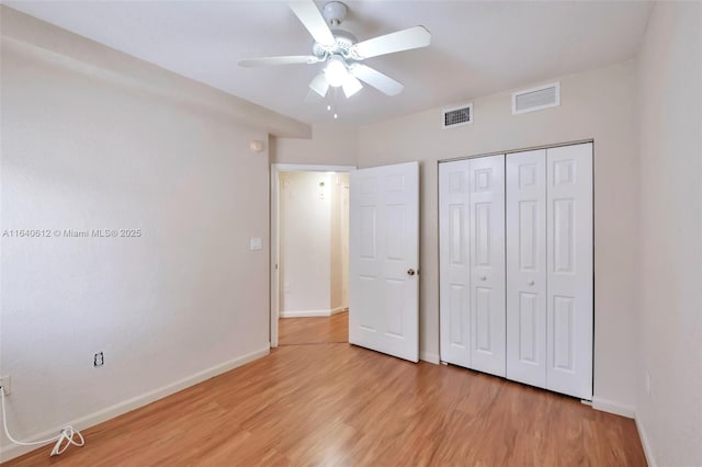 unfurnished bedroom featuring ceiling fan, light hardwood / wood-style floors, and a closet