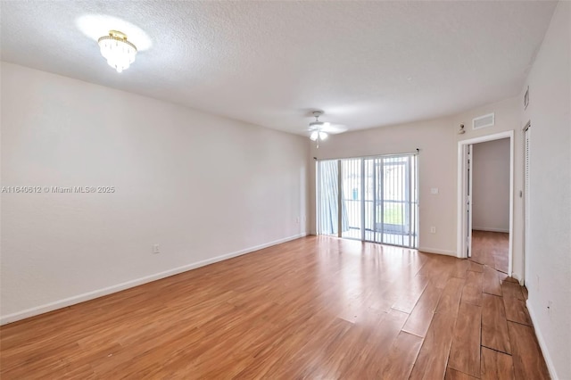 empty room with ceiling fan, a textured ceiling, and light hardwood / wood-style flooring