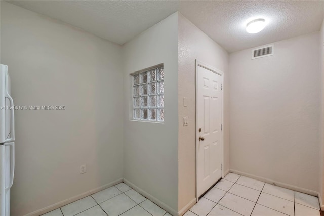 entryway featuring light tile patterned flooring and a textured ceiling