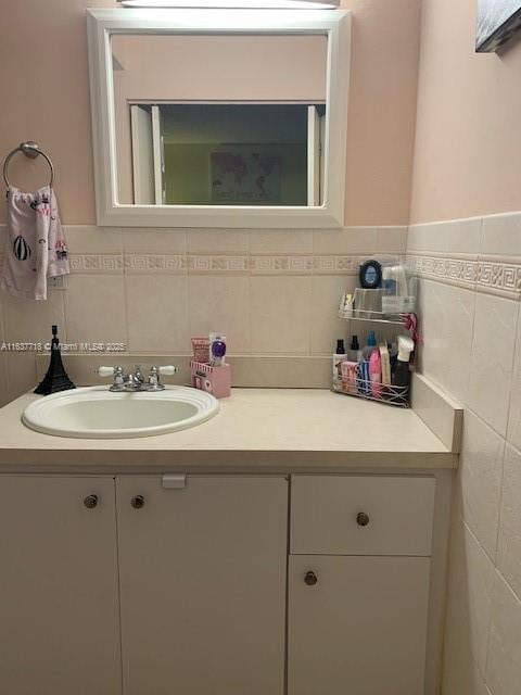 bathroom featuring vanity and tile walls