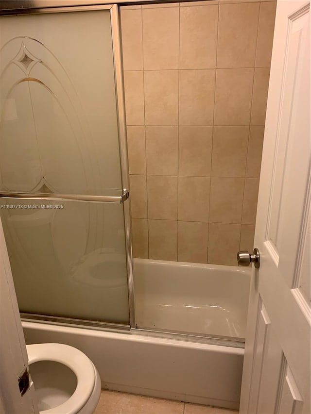 bathroom with enclosed tub / shower combo and toilet