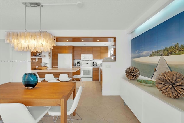 kitchen featuring decorative light fixtures, white appliances, and light tile patterned floors