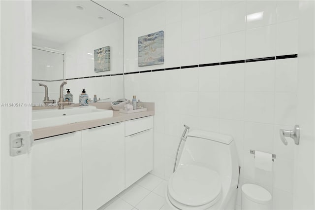 bathroom with tile walls, vanity, tile patterned flooring, and toilet