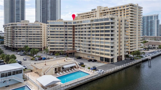 view of building exterior featuring a community pool and a water view