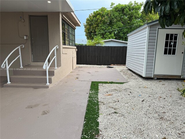 view of yard with a patio and a storage unit