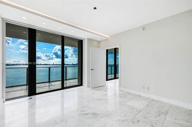 empty room with a water view and tile patterned flooring