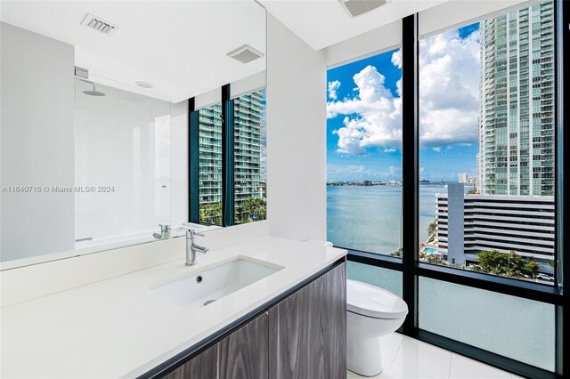 bathroom featuring tile patterned floors, vanity, toilet, and a water view