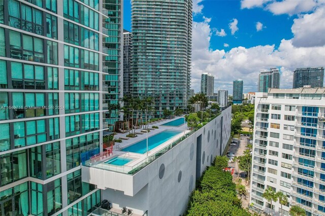 balcony featuring a pool with hot tub