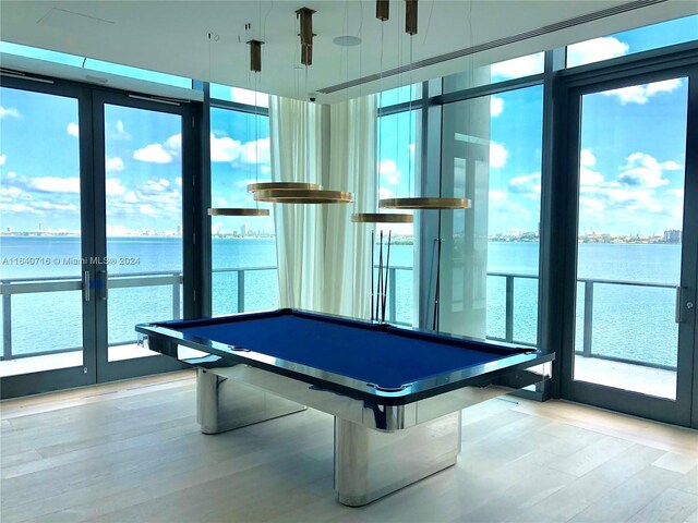 recreation room with billiards, light hardwood / wood-style floors, and a healthy amount of sunlight