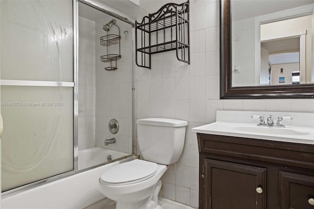 full bathroom featuring backsplash, toilet, bath / shower combo with glass door, vanity, and tile walls