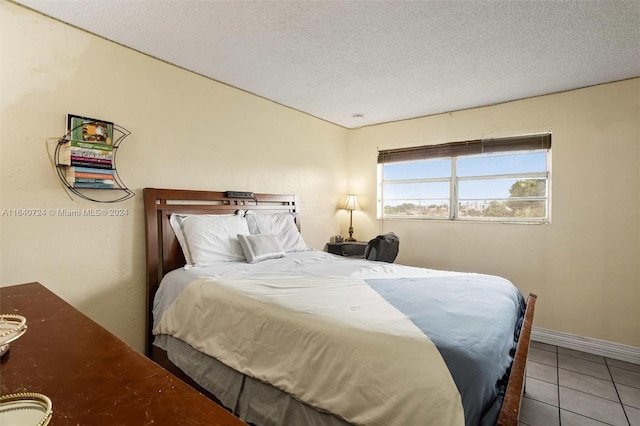 bedroom featuring tile patterned flooring and a textured ceiling