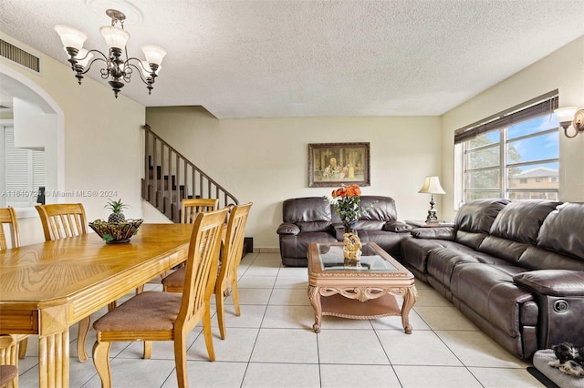 tiled living room featuring a textured ceiling and a notable chandelier