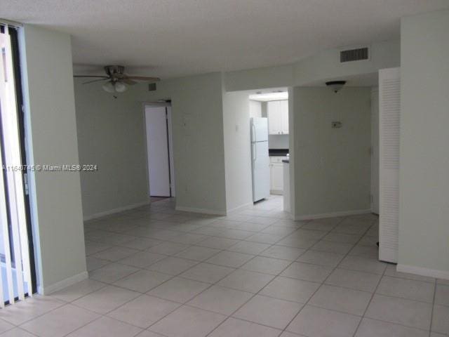 tiled spare room featuring ceiling fan