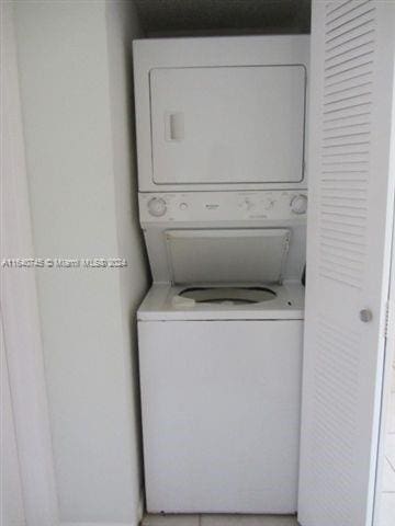 clothes washing area with stacked washer and dryer