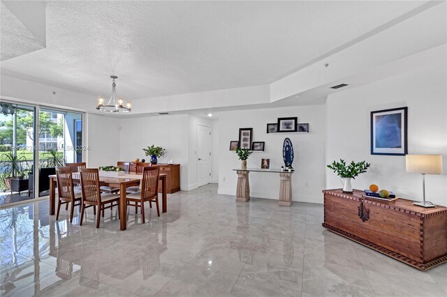 dining room featuring a textured ceiling, light tile patterned flooring, and an inviting chandelier