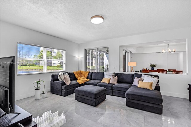 living room featuring a textured ceiling, a chandelier, and light tile patterned floors