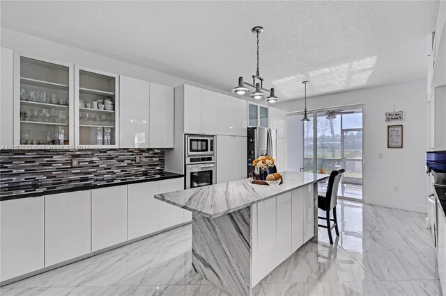 kitchen featuring appliances with stainless steel finishes, a kitchen bar, light tile patterned floors, and white cabinets