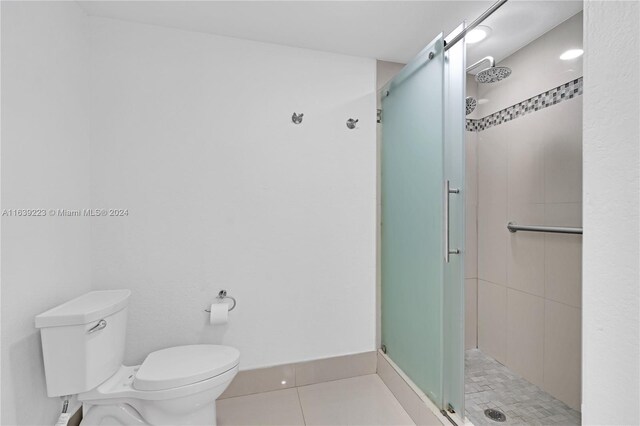 bathroom with toilet, tile patterned flooring, and an enclosed shower