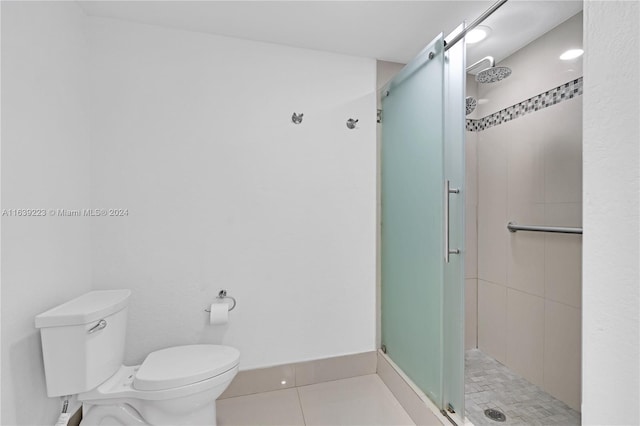 bathroom featuring toilet, a stall shower, and tile patterned flooring