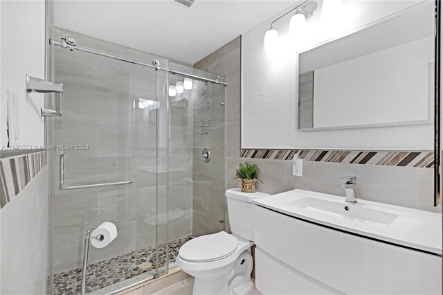 bathroom with vanity, walk in shower, and toilet