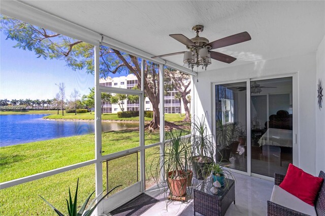 sunroom / solarium featuring ceiling fan and a water view