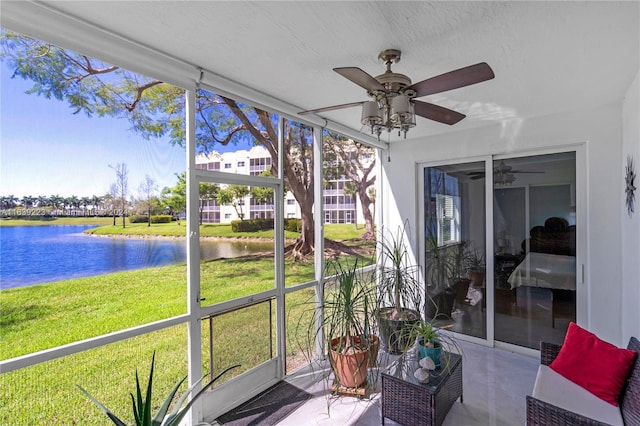 sunroom / solarium featuring a water view and a ceiling fan