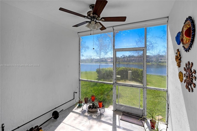 sunroom featuring a water view and ceiling fan