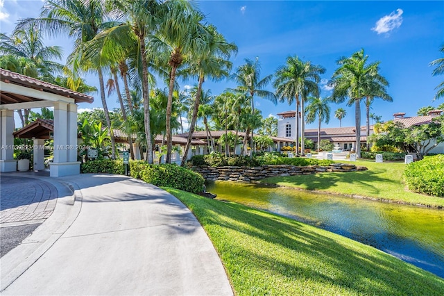 view of property's community with a water view and a yard