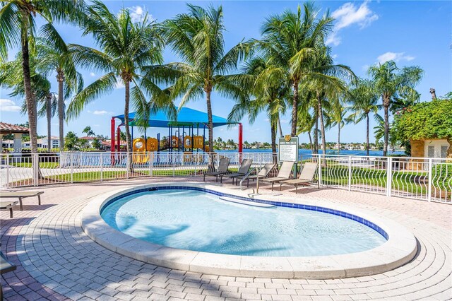 view of swimming pool featuring a playground and a water view